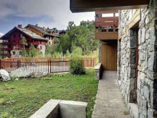 Discover a stunning property with a unique stone facade and a charming wooden balcony.