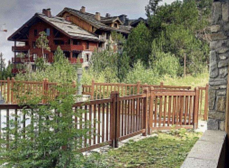 Discover a charming property nestled in a picturesque setting, featuring a beautifully crafted wooden fence that enhances its curb appeal.