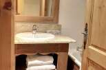 This charming bathroom features a rustic wooden vanity with a granite countertop and a built-in sink.
