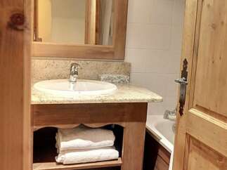 This charming bathroom features a rustic wooden vanity with a granite countertop and a built-in sink.