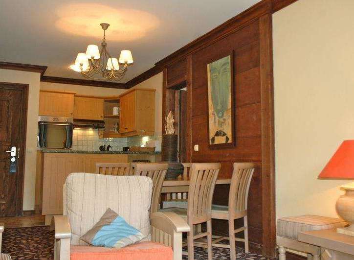 This charming property features a cozy living area with a comfortable armchair and a dining space perfect for intimate meals.