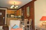 This charming property features a cozy living area with a comfortable armchair and a dining space perfect for intimate meals.