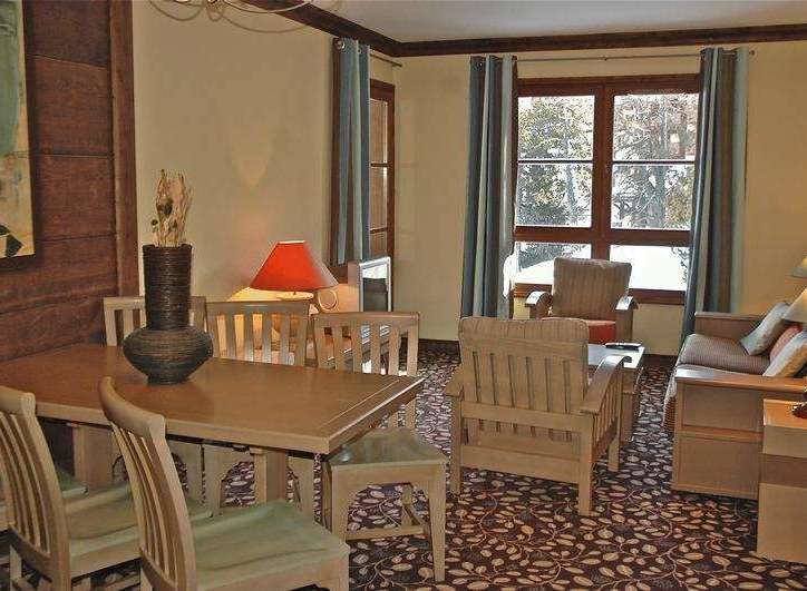 This cozy living space features a dining area with a wooden table and chairs, perfect for enjoying meals.