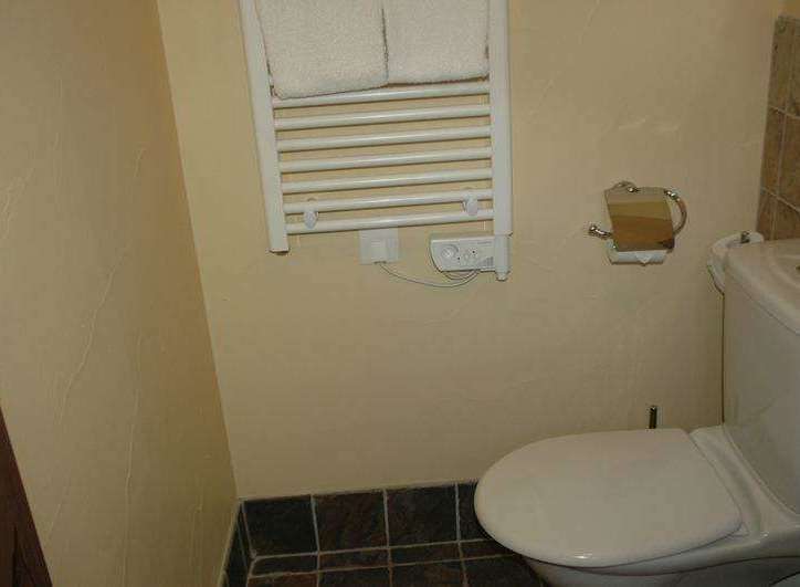This cozy bathroom features a heated towel rack, perfect for warming up towels.