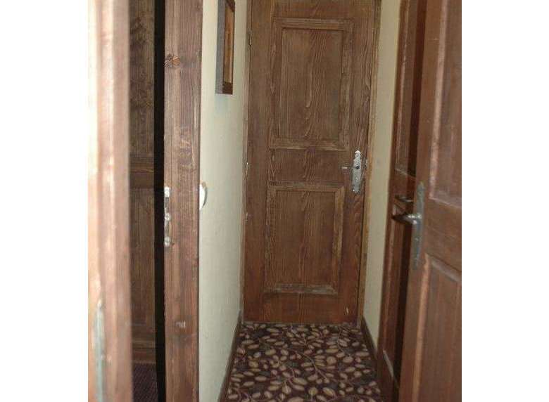 Explore the inviting ambiance of this property, featuring warm wooden doors that exude a classic charm.