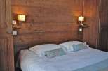 Cozy bedroom with wooden paneling and a comfortable bed.