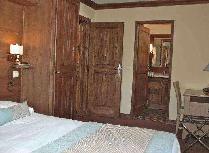 This cozy hotel room features beautiful wooden accents and a comfortable bed, perfect for a relaxing stay.