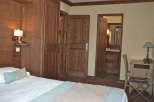 This cozy hotel room features beautiful wooden accents and a comfortable bed, perfect for a relaxing stay.