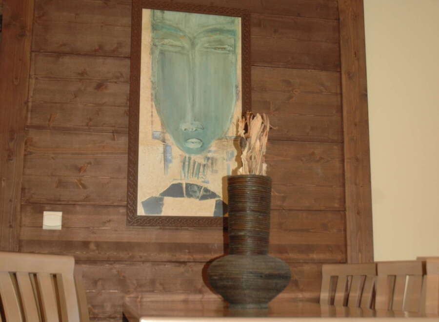 Experience elegant dining in this beautifully appointed space, featuring a striking abstract art piece and a unique decorative vase.