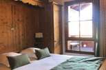 Cozy bedroom with wooden paneling and a comfortable bed.