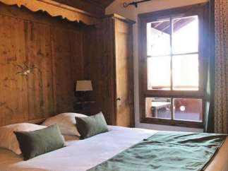 Cozy bedroom with wooden paneling and a comfortable bed.