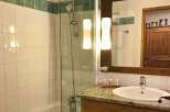 This charming bathroom features a sleek glass shower enclosure and a classic white sink.
