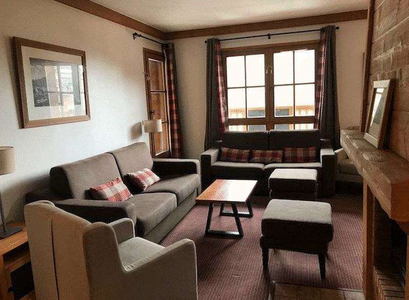 Cozy living room with comfortable seating and a warm fireplace.