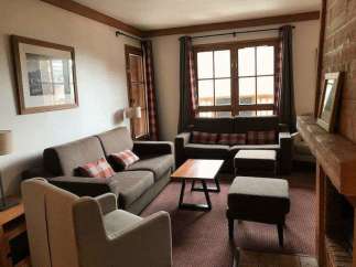 Cozy living room with comfortable seating and a warm fireplace.