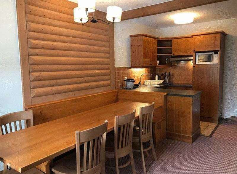 This charming property features a cozy dining area with a wooden table and chairs, perfect for enjoying meals.