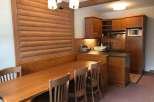 This charming property features a cozy dining area with a wooden table and chairs, perfect for enjoying meals.