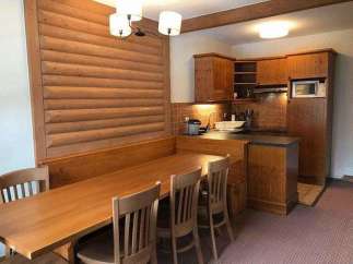 This charming property features a cozy dining area with a wooden table and chairs, perfect for enjoying meals.