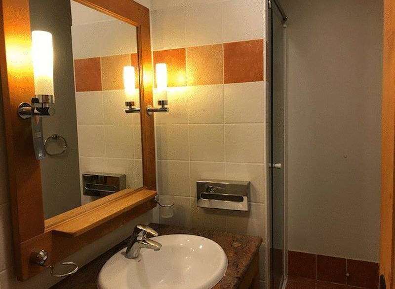 This bathroom features a stylish mirror with integrated lighting, creating a bright and inviting space.