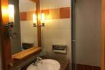 This bathroom features a stylish mirror with integrated lighting, creating a bright and inviting space.