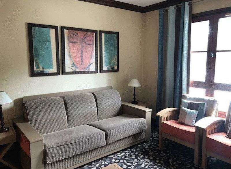 This cozy living space features a comfortable sofa and charming artwork, perfect for relaxing.