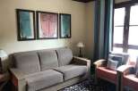 This cozy living space features a comfortable sofa and charming artwork, perfect for relaxing.