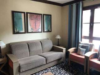 This cozy living space features a comfortable sofa and charming artwork, perfect for relaxing.