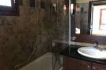 This bathroom features a sleek design with a modern vanity and a stylish sink.