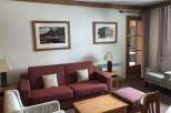 Cozy living room with a comfortable red sofa and two armchairs, perfect for relaxing.