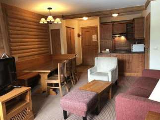 This cozy living space features a rustic wooden dining set, perfect for family meals.