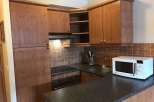 This charming kitchen features wooden cabinetry and a sleek countertop, creating a warm and inviting atmosphere.