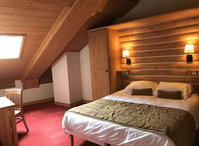 Experience the charm of this cozy attic bedroom, featuring a unique wooden ceiling and walls that create a warm and inviting atmosphere.