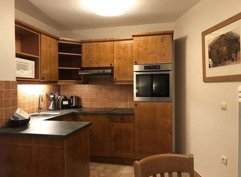 This charming kitchen features warm wooden cabinetry and a modern built-in oven, creating a cozy and functional space.