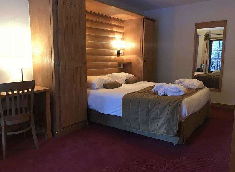 Cozy and inviting hotel room featuring a comfortable bed with plush bedding and a warm, inviting atmosphere.