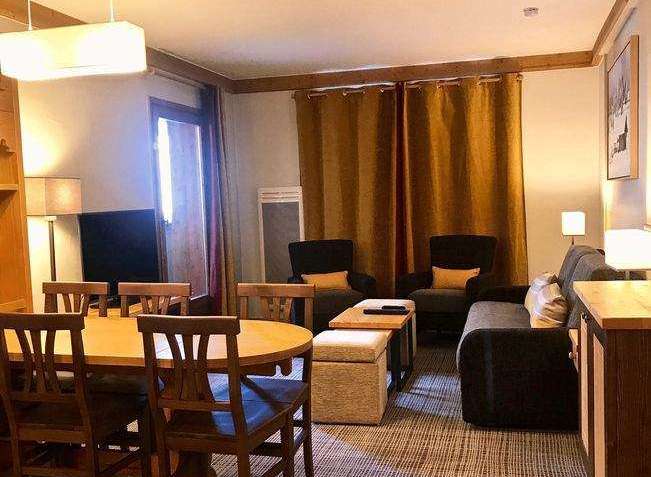 This cozy living space features a dining area with a wooden table and chairs, perfect for meals and gatherings.