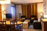 This cozy living space features a dining area with a wooden table and chairs, perfect for meals and gatherings.