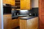 This charming kitchen features warm wooden cabinetry, creating a cozy and inviting atmosphere.