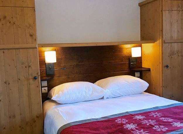 Cozy bedroom with wooden accents and a comfortable bed.
