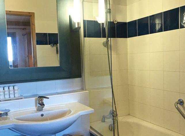 This bathroom features a stylish design with a modern sink and a sleek shower setup.