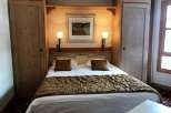 Cozy bedroom with a comfortable bed and warm lighting.