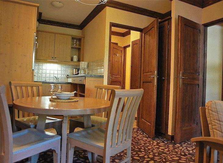 Cozy kitchen with a round dining table and chairs, perfect for enjoying meals.