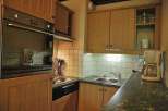 This cozy kitchen features wooden cabinets and a built-in oven, perfect for preparing meals.