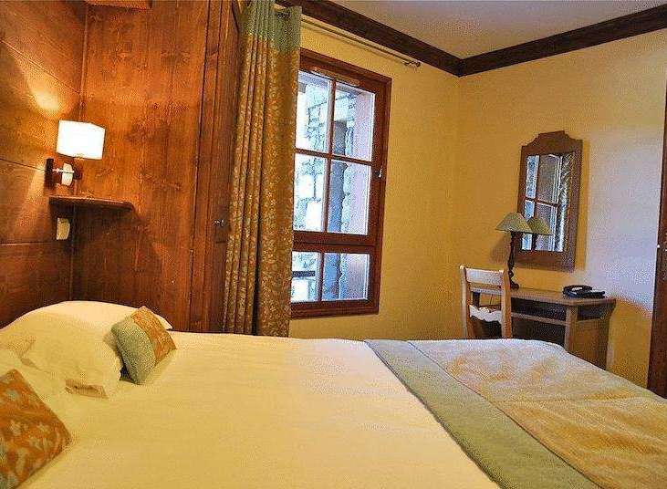 Cozy bedroom with wooden accents and a comfortable bed.