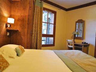 Cozy bedroom with wooden accents and a comfortable bed.
