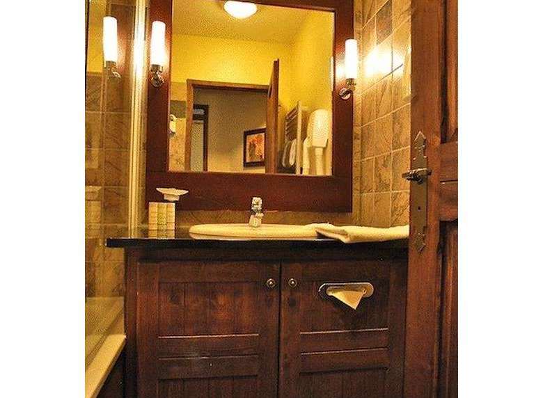 This bathroom features a classic design with a dark wood vanity and a large mirror.