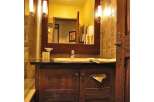 This bathroom features a classic design with a dark wood vanity and a large mirror.