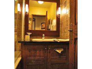 This bathroom features a classic design with a dark wood vanity and a large mirror.