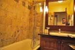 This bathroom features a warm and inviting design with its tiled walls and wooden vanity.