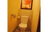 This cozy bathroom features a stylish toilet and a unique piece of art, creating a welcoming atmosphere.