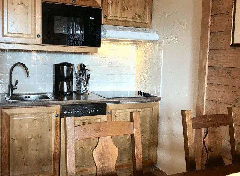 This charming kitchen features rustic wooden cabinetry and a modern microwave.