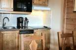 This charming kitchen features rustic wooden cabinetry and a modern microwave.